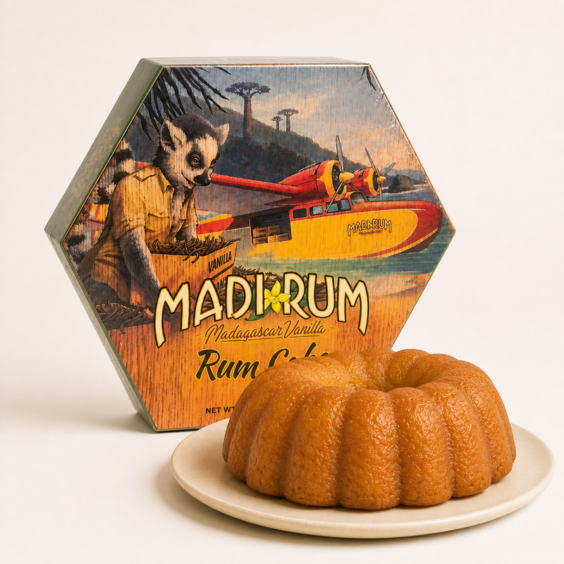 Madi Rum Madagascar Vanilla Rum Cake in its illustrated hexagonal box, with the ring-shaped cake on a plate beside it